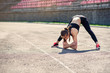 © gorynvd - Fitness girl doing stretching on the sadium before training. Fitness female athlete doing a warm up before her strength training cardio workout.