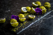 pistachio and cheese coated grapes  with flower decoration on black slate plate 