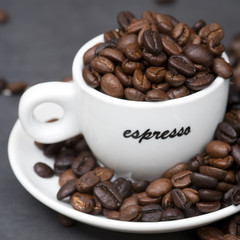 Wall Mural - Still life of roast coffee beans and espresso cups on a tiled kitchen work surface