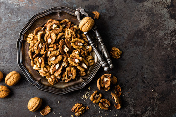 Poster - Walnut kernels and whole walnuts on rustic old wooden table