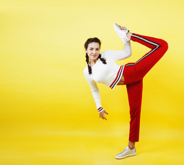 young pretty teenage woman happy smiling posing on yellow backgr