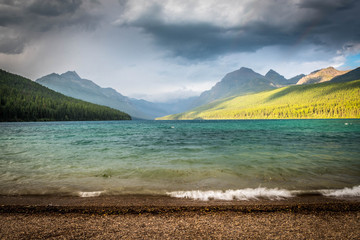 Wall Mural - lake waves washing on the shore, mountains over the lake