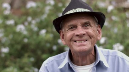 Wall Mural - Outdoor shot of smiling senior man in hat