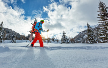 Wall Mural - Snowboarder walking on snowshoes in powder snow.