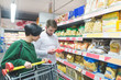 © bodnarphoto - A young couple selects the products in the supermarket. The couple picks up pasta. Family shopping in a supermarket