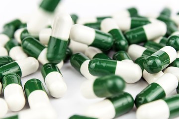 green-white pills on a white background. Pharmaceutical industry. Development of new drugs.