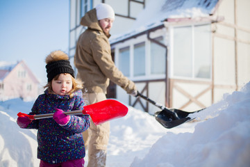 Wall Mural - Little girl with a snow shovel.