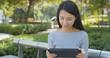 © leungchopan - Woman using tablet computer at outdoor