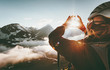 Woman hands Heart symbol shaped Travel Lifestyle and Feelings concept with sunset mountains on background.