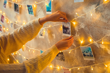 Young woman weekend at home decorated bedroom sticking photo