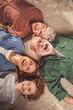 © Yakobchuk Olena - Top view portrait of laughing woman with son, smiling grandmother and granddad locating on carpet. Relax and fun concept
