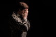 Despondent young soldier covering his face with hands. Concept of sorrow. Isolated on background. Copy space in right side