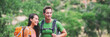 © Maridav - Happy hikers hiking in forest outdoor active lifestyle people panorama banner with green background. Camping couple with bags smiling.