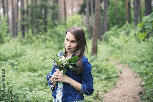 Fotografía Young woman with lily in hand, unity with nature