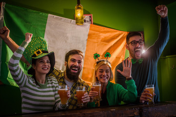 Wall Mural - Group of Friends Celebrating St Patrick's Day in Beer Pub