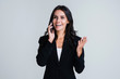 © MARIIA - Great news. Beautiful young businesswoman talking on her smartphone with smile while standing against white background