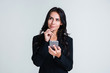© MARIIA - Shall I send this message? Beautiful young businesswoman using her smartphone and looking pensive while standing against white background