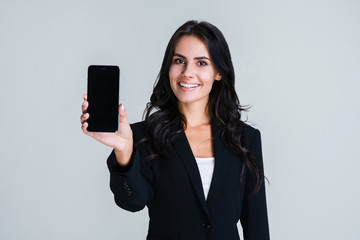 have you seen this app? beautiful young businesswoman showing her smartphone and looking at camera w