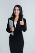 © MARIIA - Business cutie. Beautiful young businesswoman holding her laptop and gesturing thumb up with smile while standing against white background