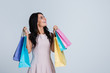 © MARIIA - Looking up for shopping. Beautiful young woman holding shopping bags and looking up with smile while standing against white background