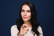 © MARIIA - I nee you. Portrait of beautiful young woman looking at camera and pointing you while standing against black background