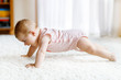 © Irina Schmidt - Little funny baby girl lifting body and learning to crawl.