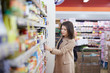 © Stocked House Studio - young woman buy can of tuna at supermarket