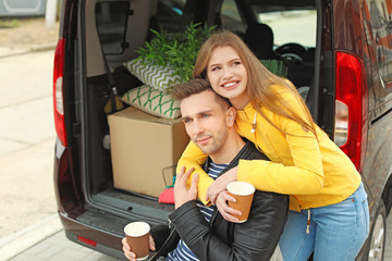 Poster - Young couple having break near their car on moving day