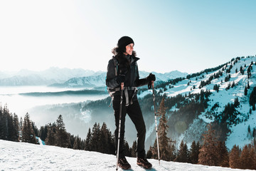 Wall Mural - young smiling woman hiking in snowy mountains