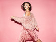 Leinwandbild Motiv young fashion woman in pink clothes run on pink background