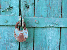 Old Metal Padlock On The Locked Wooden Doors. Home Security Concept