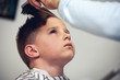 © Artem - Barber shop. Barbershop hairdresser makes hairstyle to a boy.