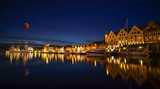 Fototapeta Miasto - A night long exposure photography of Bergen at harbor  with beautiful water reflection of full blue moon