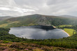 Beautiful lake, Lough Tay in Wicklow Mountains, hilly landscape covered in heath and forest