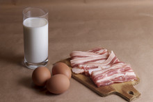 Ingredients Of Omelet With Eggs, Milk, Bacon On Wooden Cutting Board Closeup