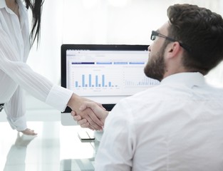 Wall Mural - employees greet each other with a handshake near the desk