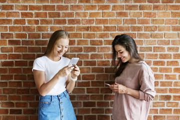 Wall Mural - happy female friends using smartphones