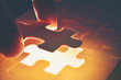 The wooden jigsaw puzzle is missing pieces that are ready to light.It is a business concept in component success.This image Soft focus.