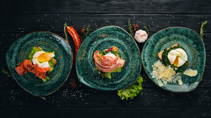 Wall Mural - Poached egg with salmon, bacon and parmesan on a wooden background. Top view. Free space for your text.