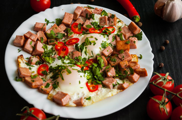 Breakfast. two fried eggs with ham on dark wooden background