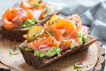 Smorrebrod With Salmon On Rye Bread With Vegetables And Herbs
