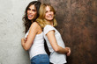 © snedorez - Picture of beautiful brunette and blond woman standing with their backs to each other