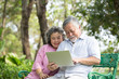 © Jestercine - Senior People using laptop for live chat with friend at outdoor park. Elder people using laptop with attractive smiling together. People lifestyle concept.