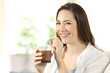 Woman drinking cocoa shake looking at camera