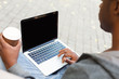 © Prostock-studio - Male hands with laptop and coffee closeup,over shoulder shot outdoors