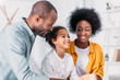 © LIGHTFIELD STUDIOS - smiling african american parents and daughter having fun at home
