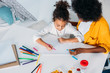 © LIGHTFIELD STUDIOS - high angle view of african american mother drawing with daughter