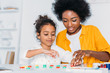 © LIGHTFIELD STUDIOS - african american mother teaching daughter numbers at home