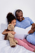 © LIGHTFIELD STUDIOS - african american father reading for daughter at home