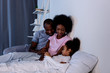 © LIGHTFIELD STUDIOS - african american parents looking at sleeping daughter